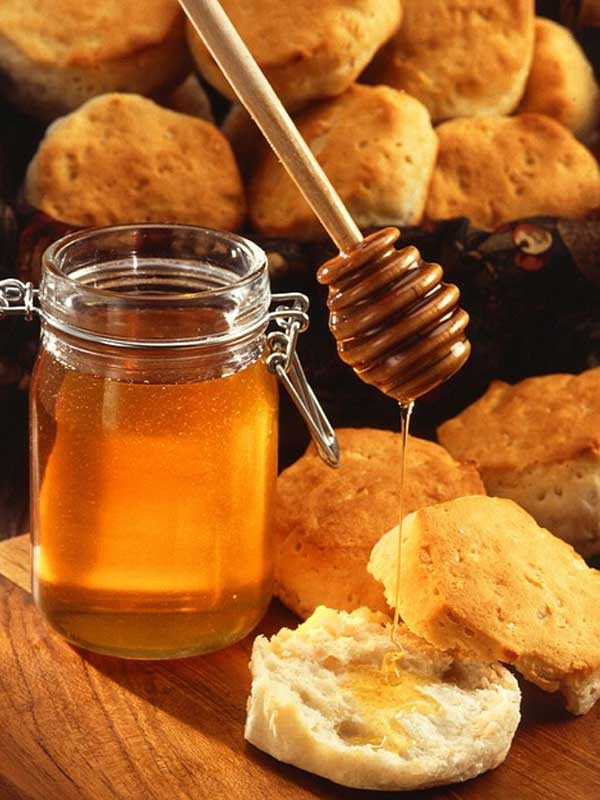 Alimentos saudáveis pote de mel puro passando no pão