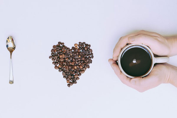 I love coffee bebida mole sendo o I representado por uma colher, o love representado por grãos de café formando um coração e o coffee representado por uma xícara cheia de café