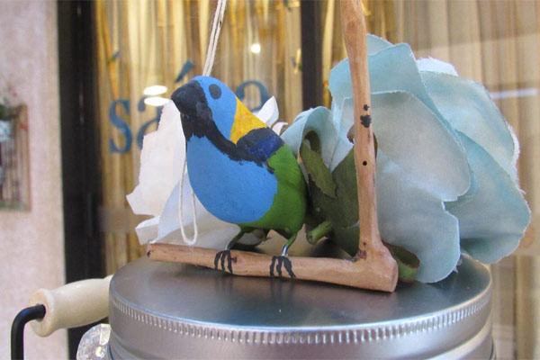 Decoração de passarinhos saíra sete cores em uma composição com bandeja e flores azuis