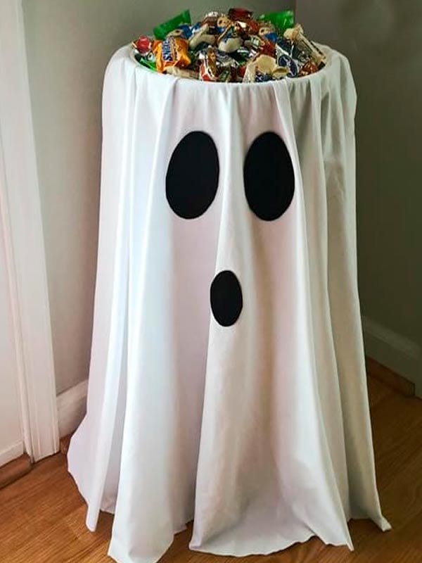 Mesa de doces coberta com um lençol branco imitando um fantasma